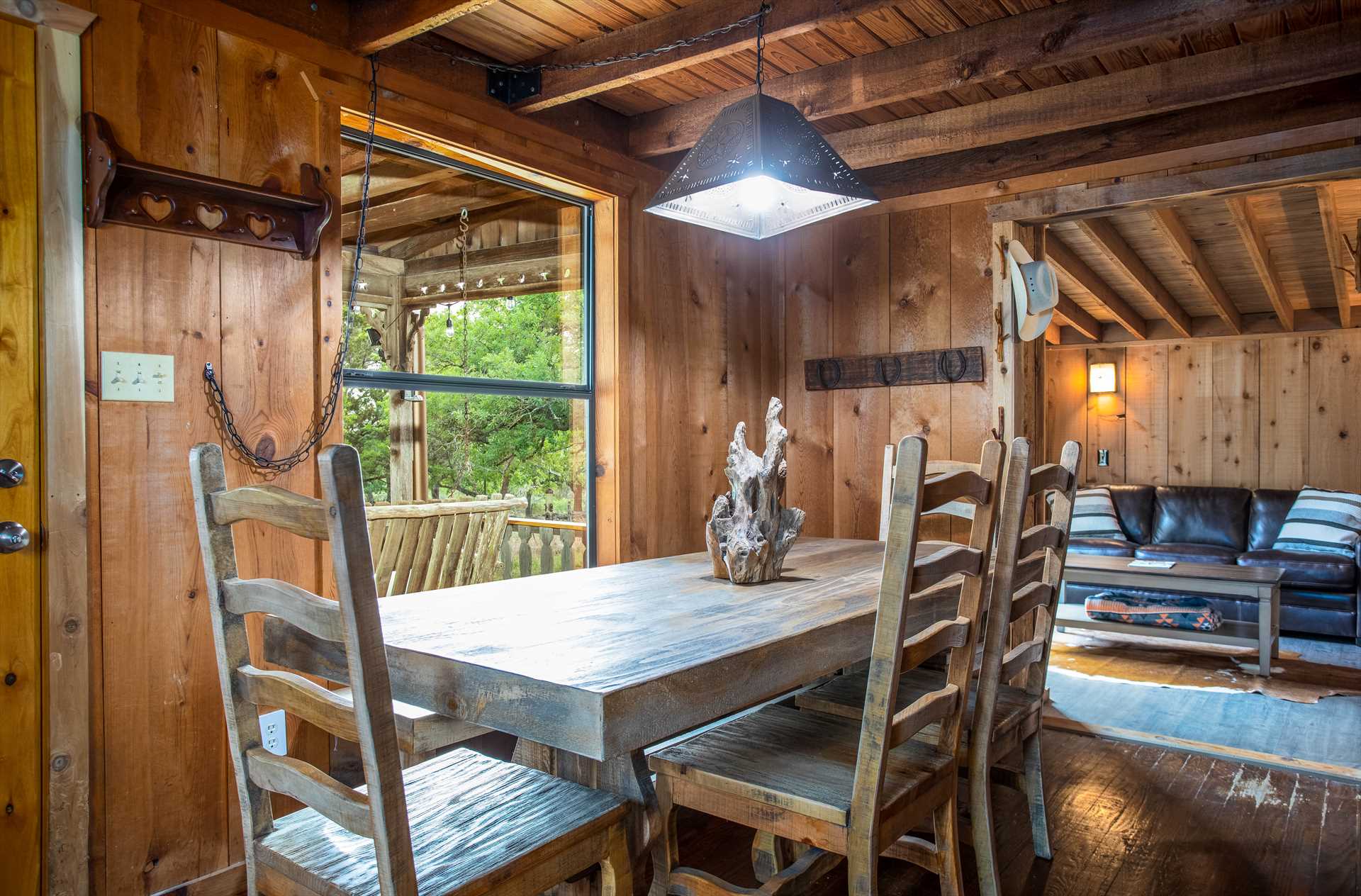 Rustic dining room with a huge window and unique art