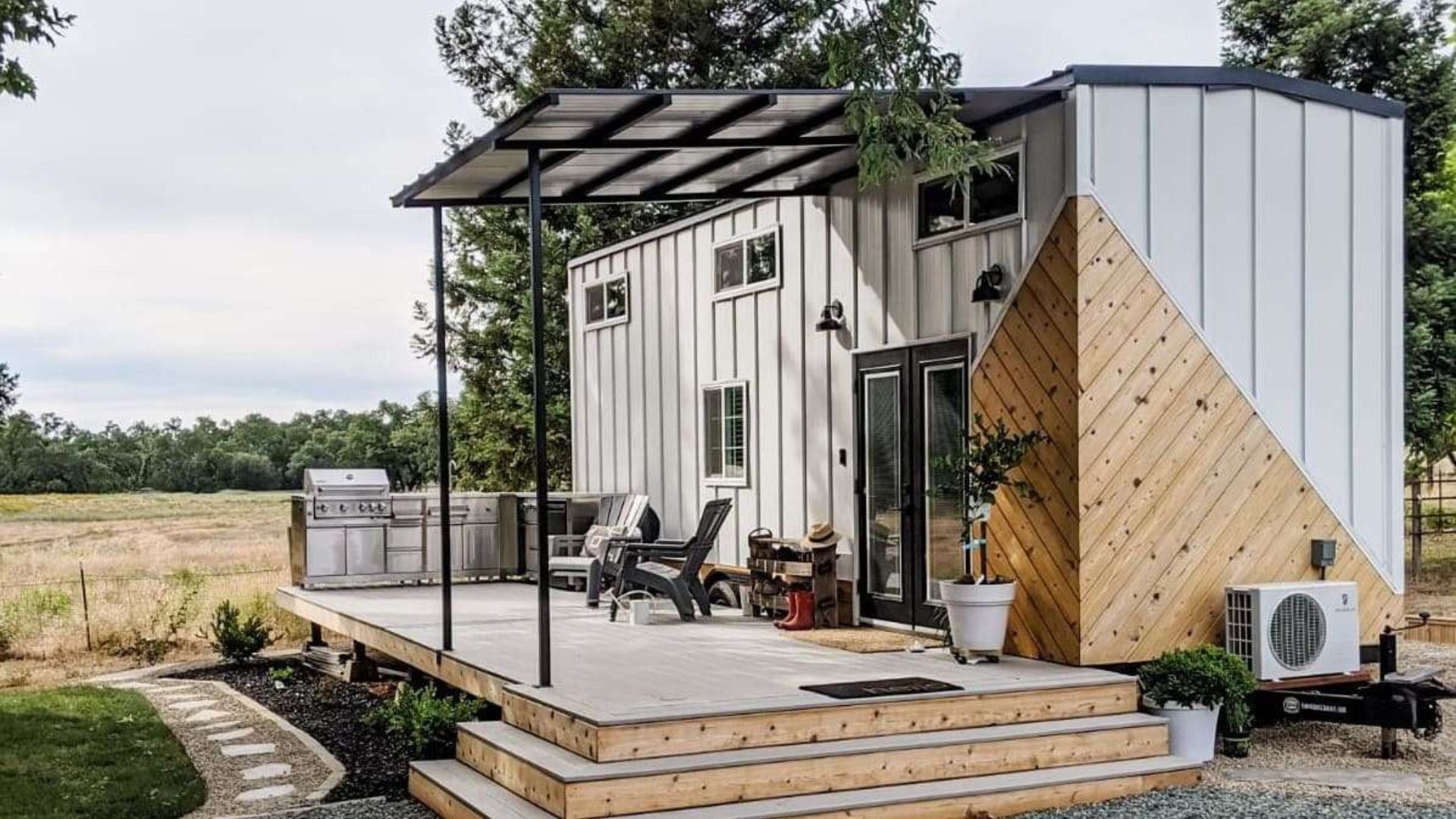 exterior of a tiny home with a porch with two chairs