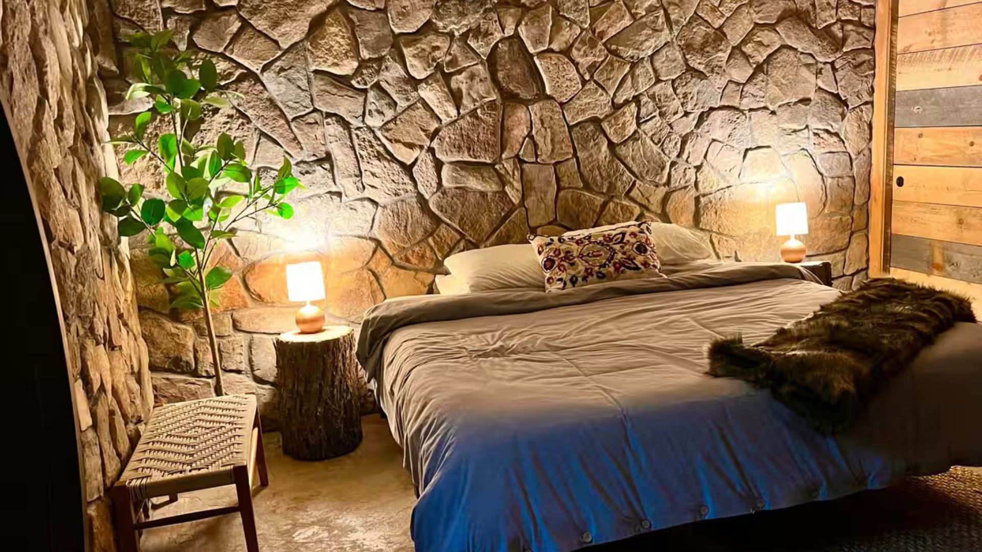 bedroom in hobbit house with stone accent wall behind it