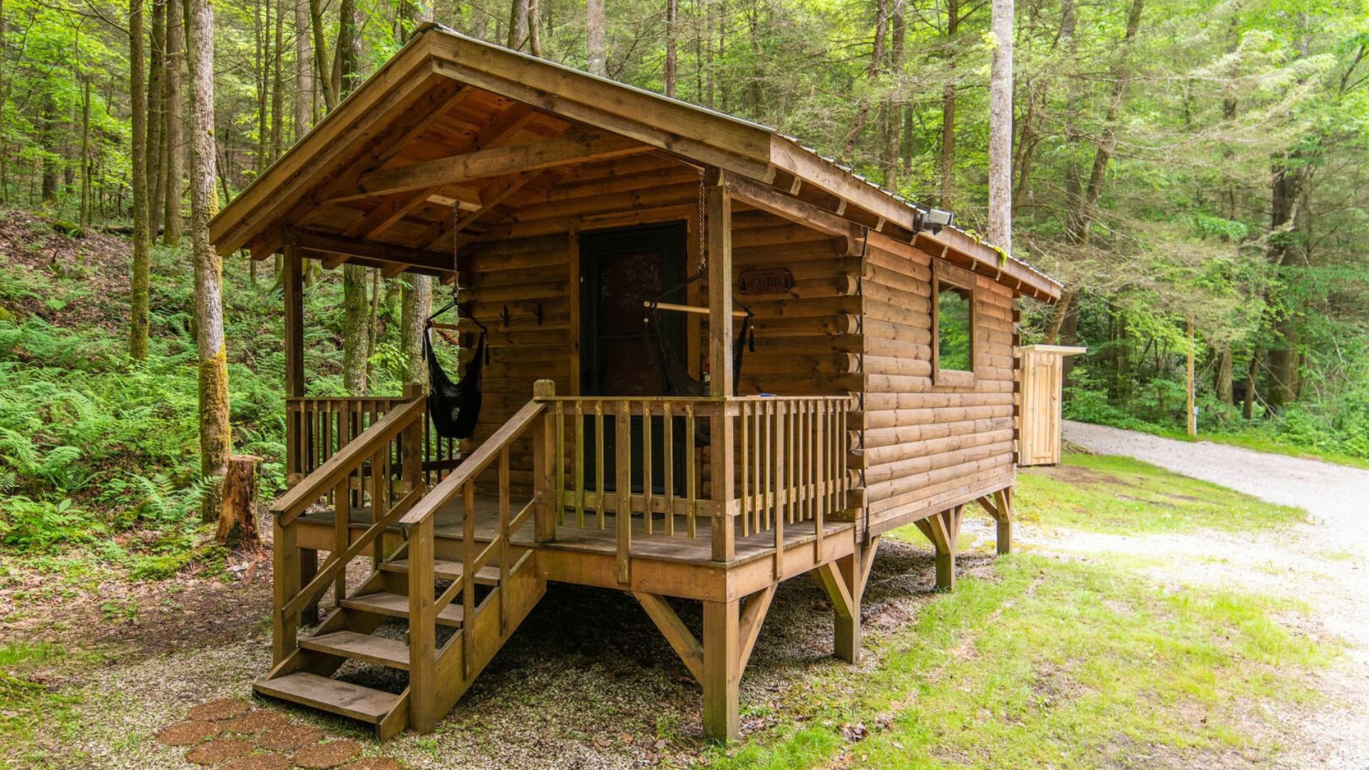 Wooden cabin with porch next to a creek