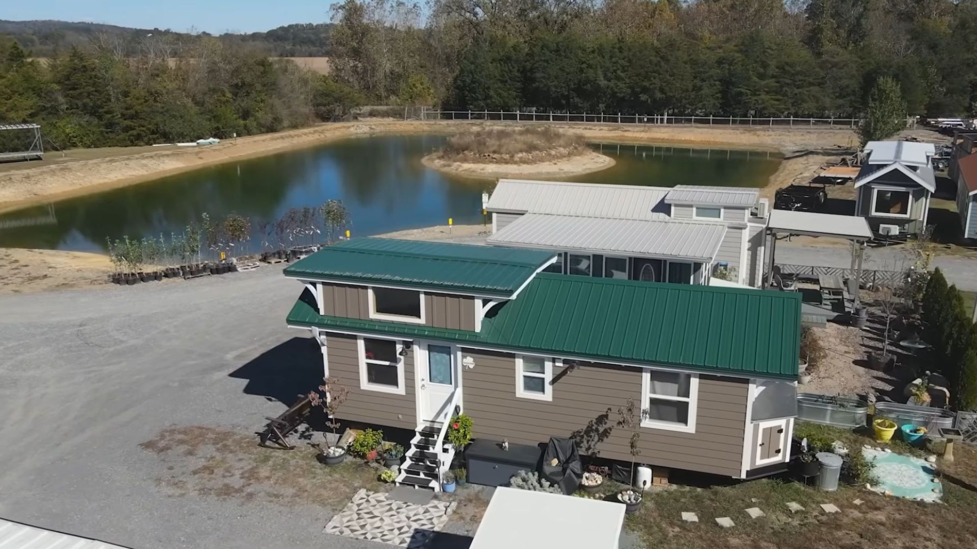 exterior of Dorothy's THOW with brown wood siding and a green metal roof, white frame around the door and windows