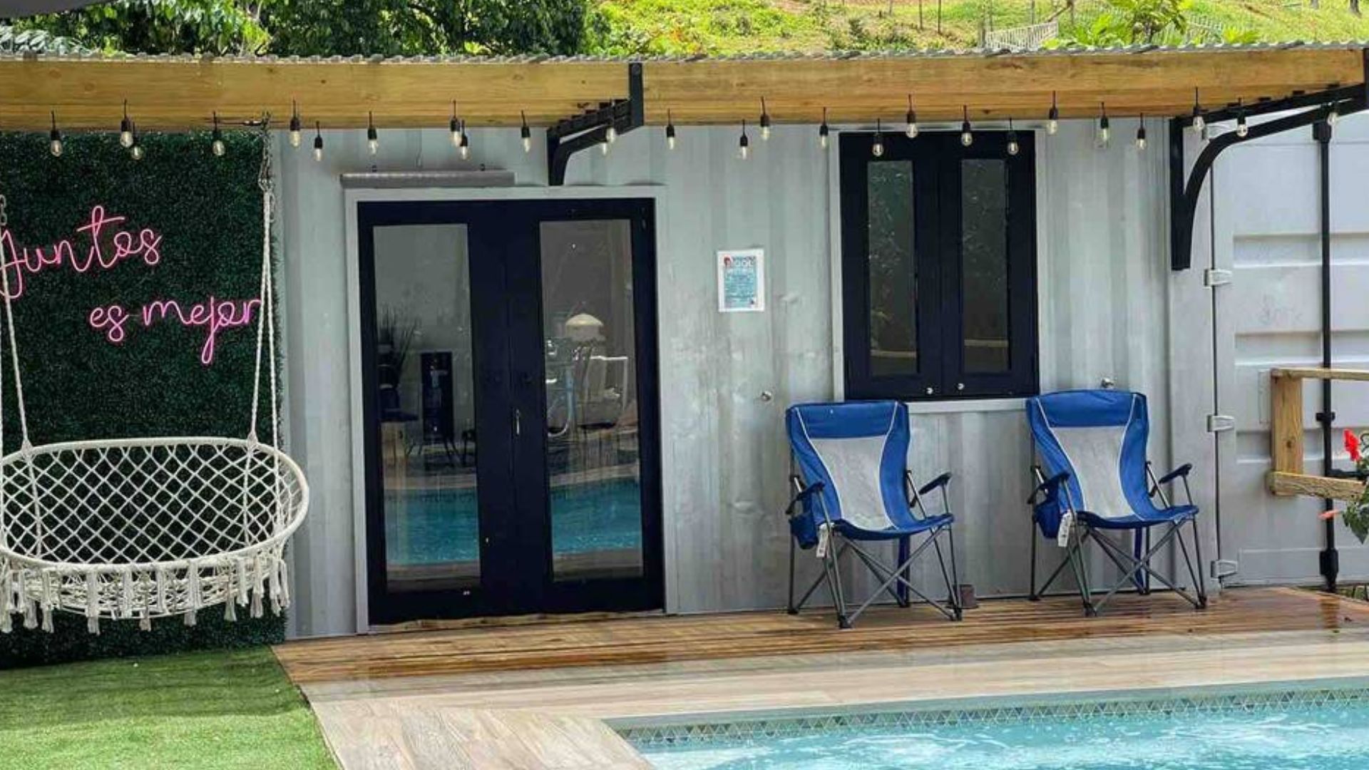 exterior of a container house with a pool and lounge areas