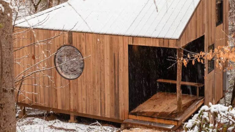 winter photo of the nook house with wooden panels as a facade and a round window