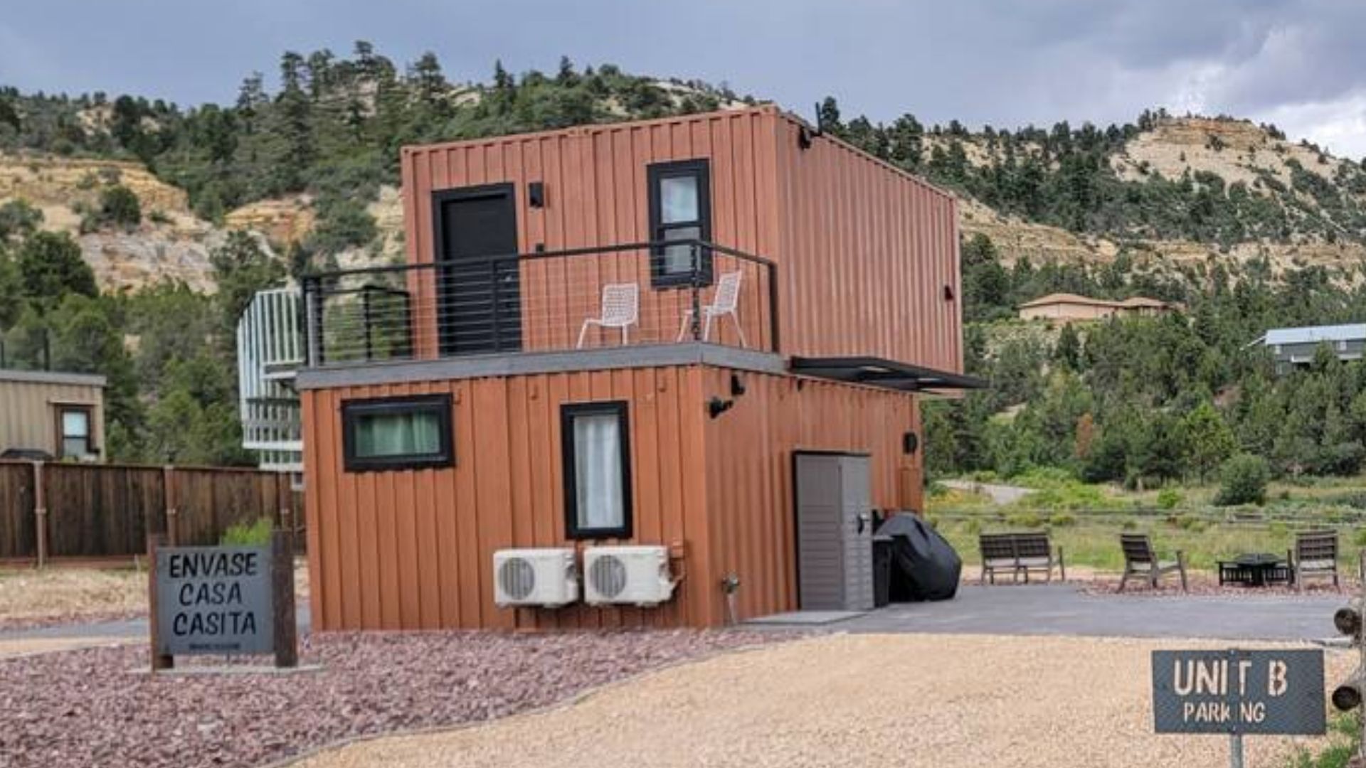 scaled container house on two levels with front walls completely in windows, copper-colored corrugated walls