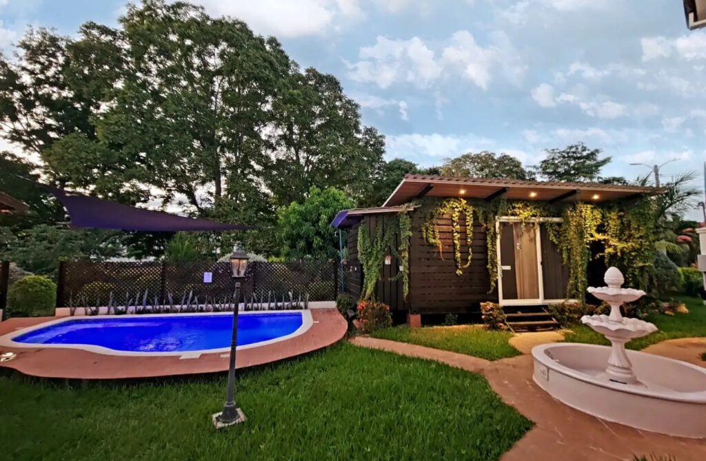 Backyard of a container home with a pool and a fountain