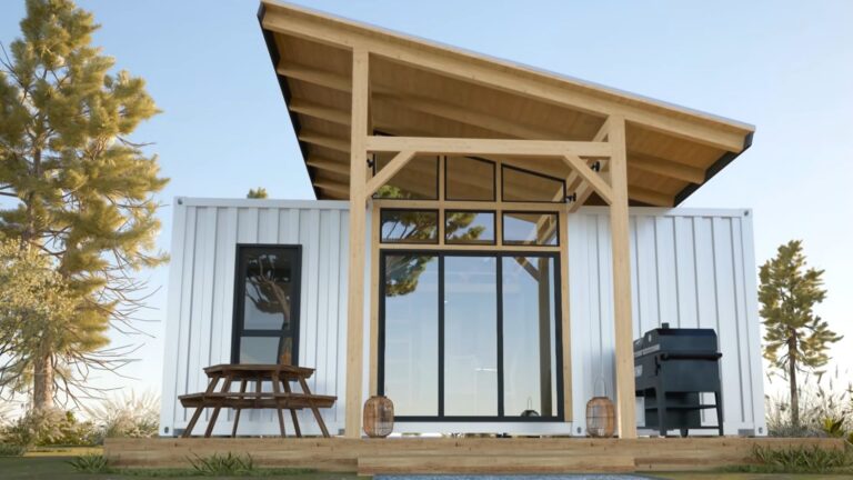 exterior of a container house with a round table and a grill in front
