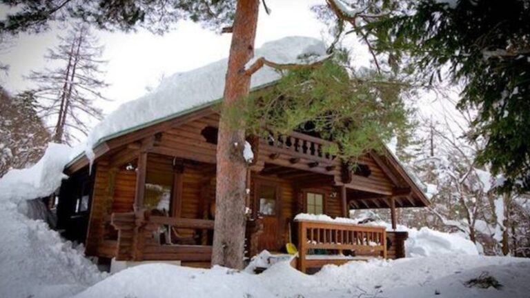 exterior of a cabin covered in snow