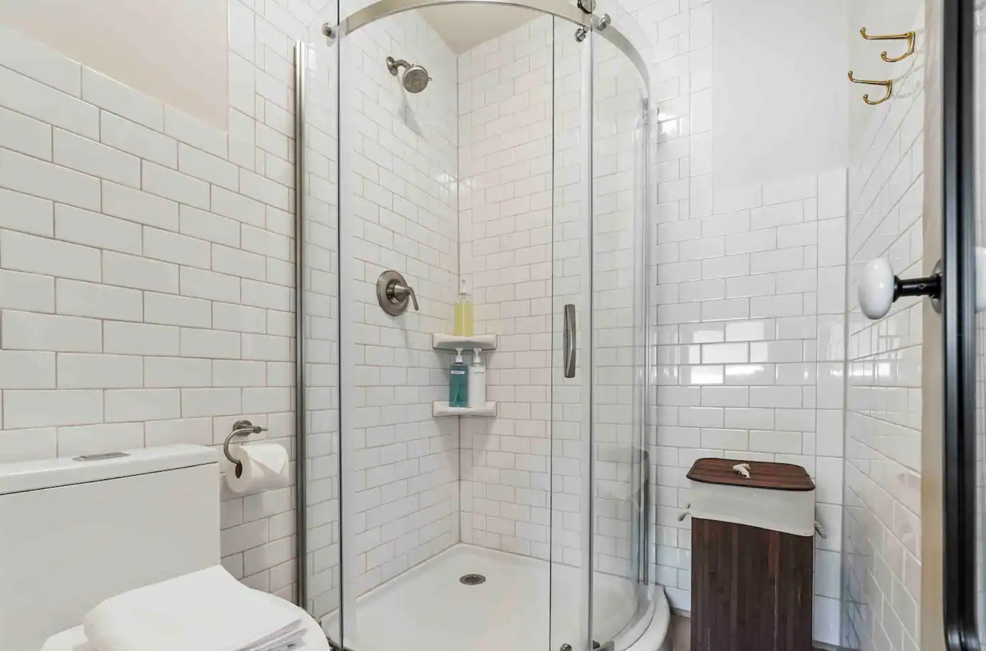 White kitchen with a walk-in shower and wooden basket