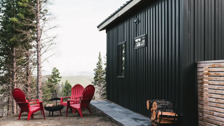 exterior of the cabin with the entrance all in windows, a small deck at the entrance, slanted roof, surrounded with treesexterior of the cabin with the entrance all in windows, a small deck at the entrance, slanted roof, surrounded with trees