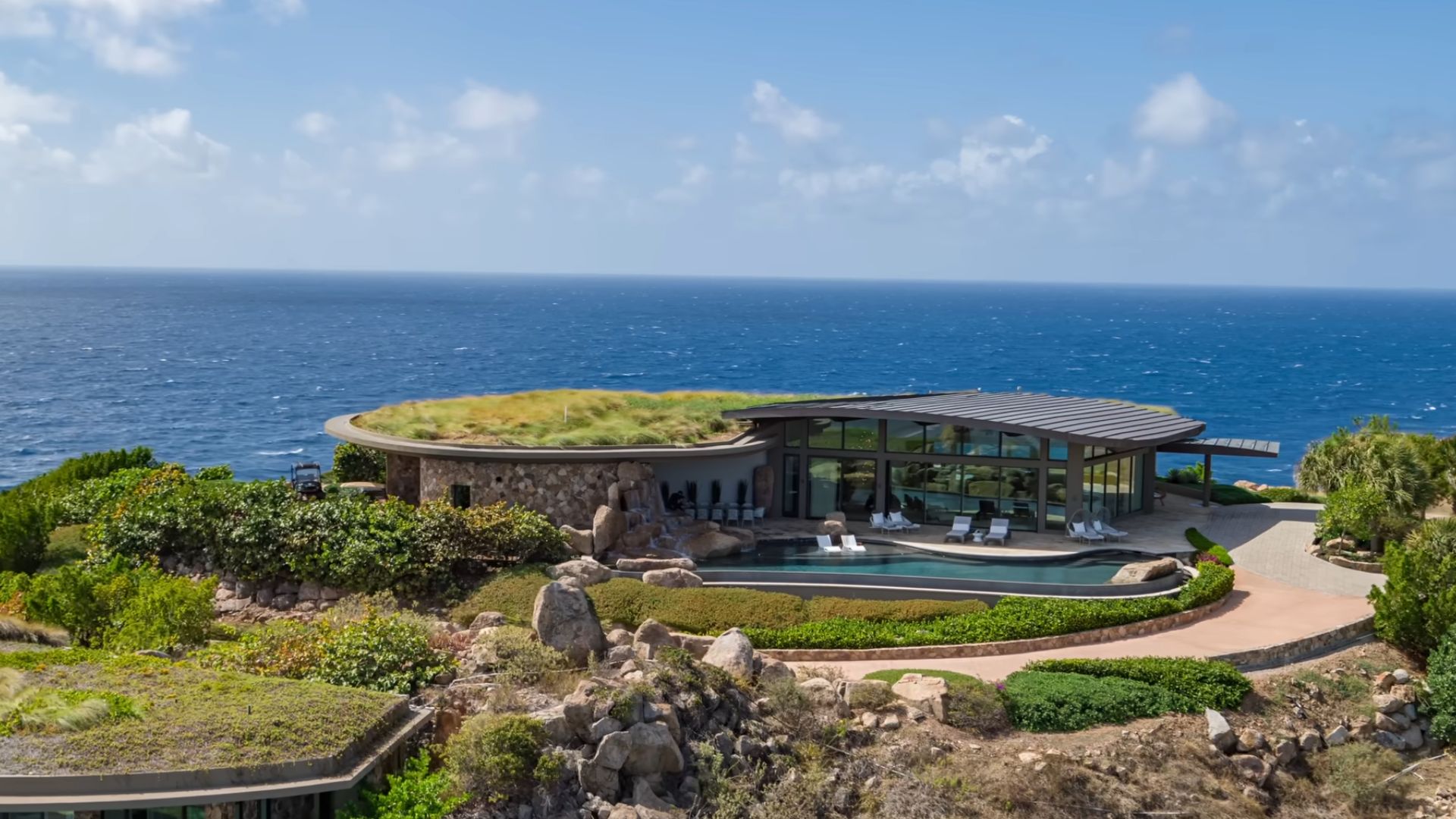 the invisible house surrounded by greenery and the ocean