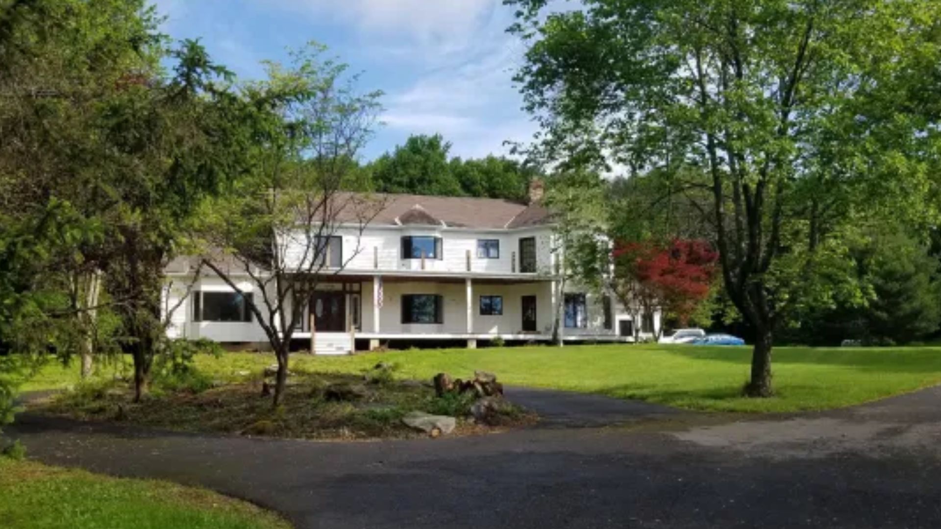 exterior of a big home with white walls and greenery