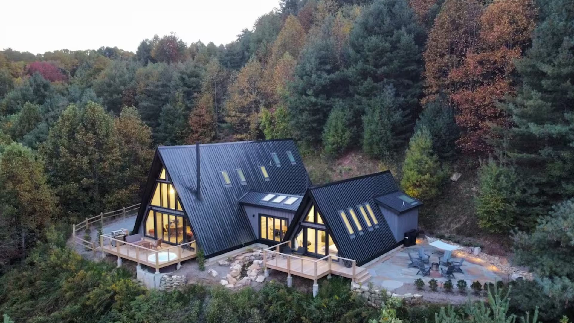 exterior of a cabin with green surroundings and a lot of windows