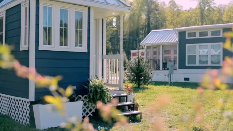 tiny house with blue and white exterior and lovely details such as the window trim and the lattice under it
