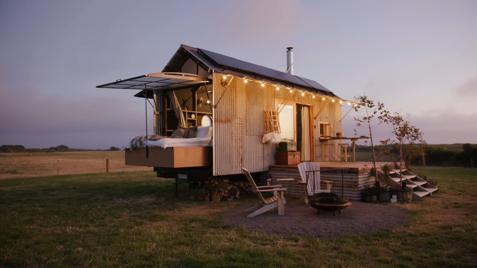 exterior of a tiny home in the middle of nowhere with small lights on it