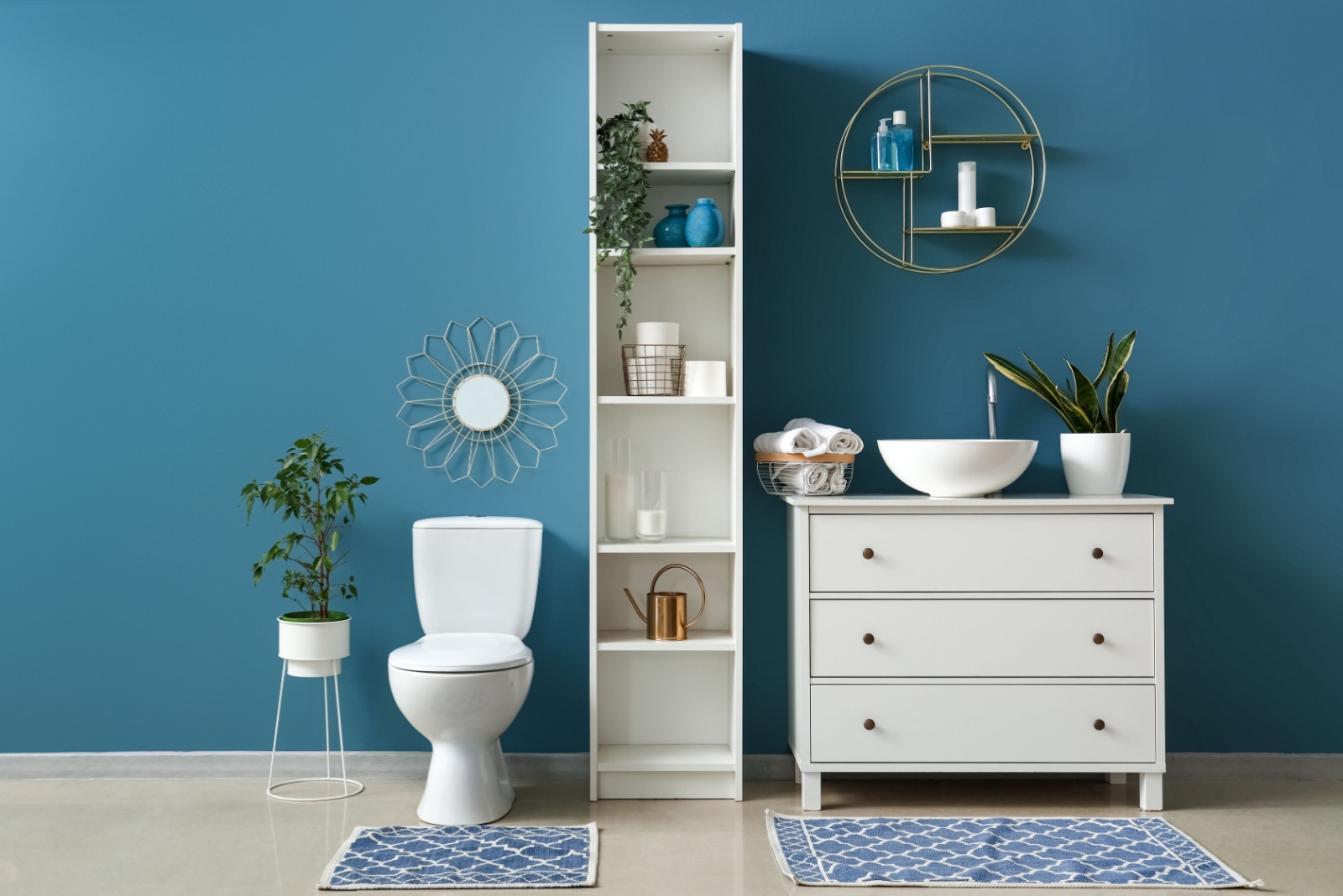 bathroom with a blue wall, white toilet, white cabinets and a white sink