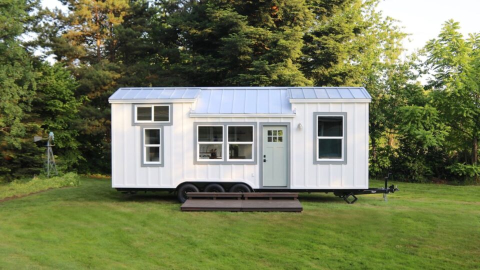 exterior of a tiny home with white walls and a lot of windows