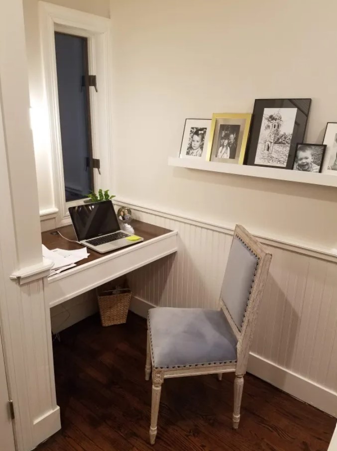 office area with a desk, chair and a shelf hung on the wall after renovating