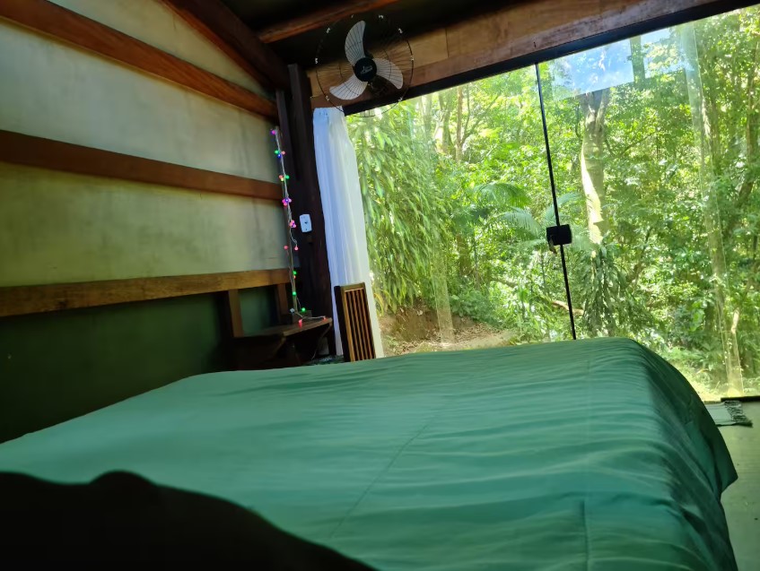 bedroom with a glass wall and green bedsheets