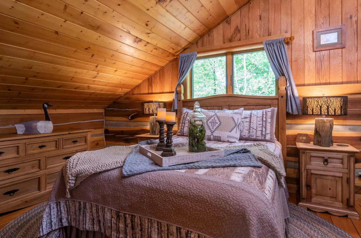 bedroom with wooden walls, wooden bedside tables, queen-sized bed