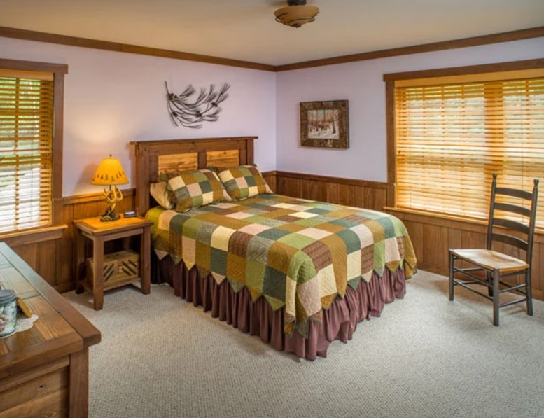 bedroom with lavender walls, two windows, wooden bed frames