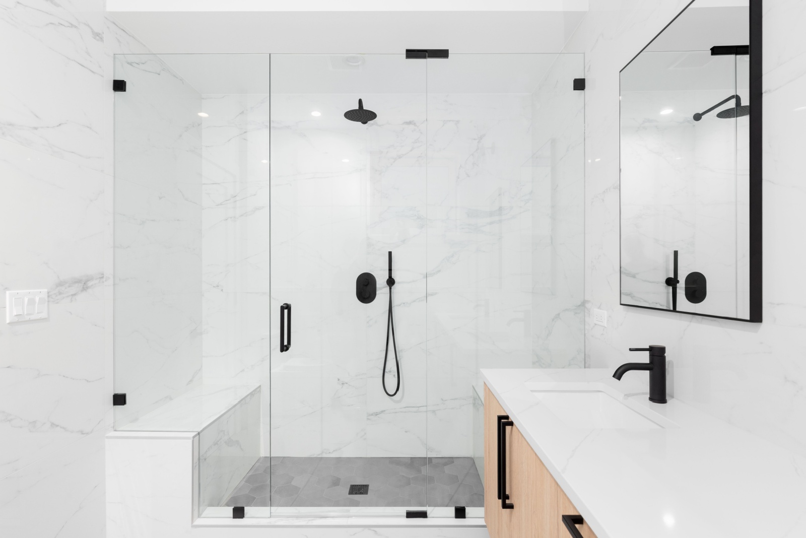 bathroom with a glass shower, brown cabinet and a white countertop and a mirror on top