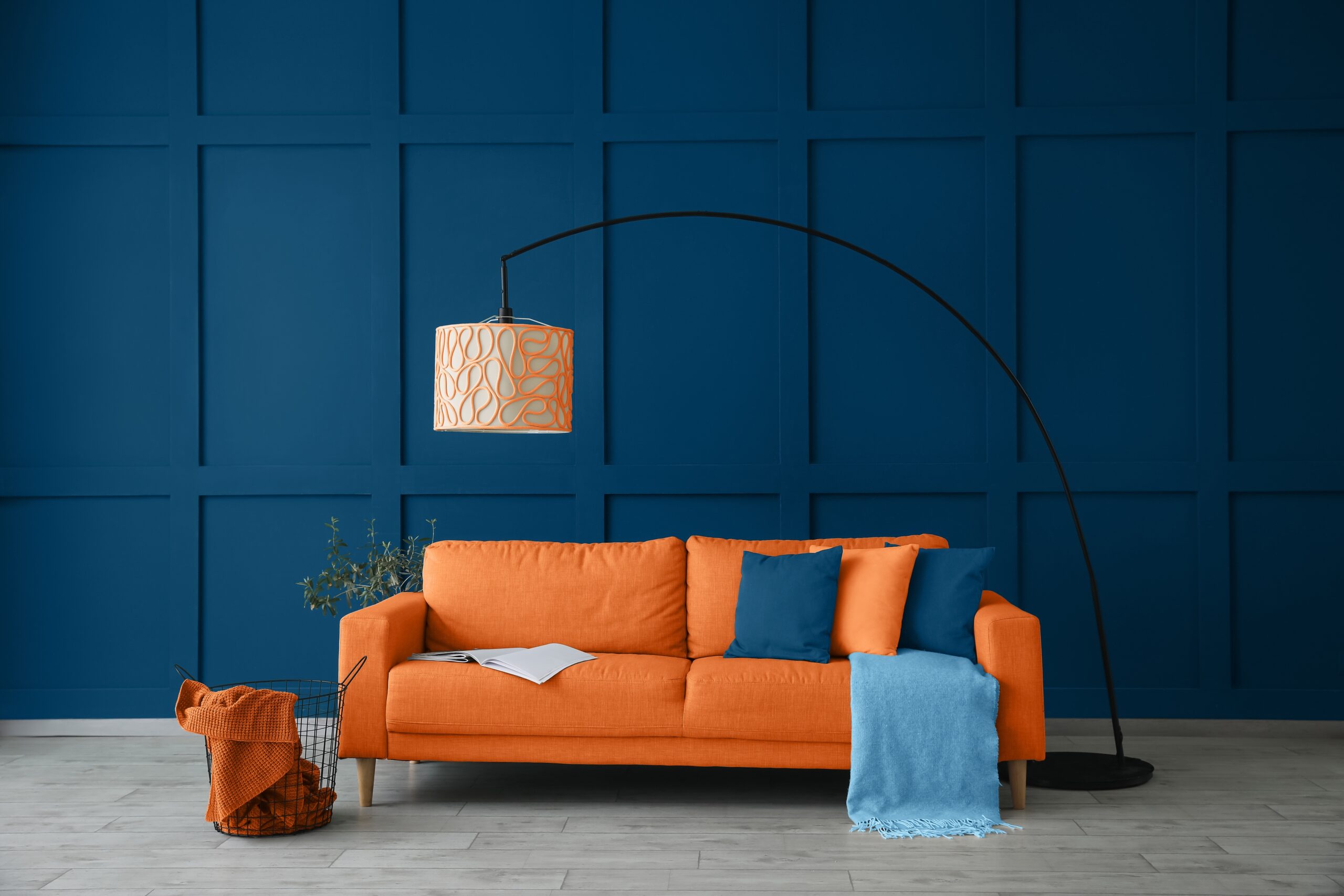 Blue living room with an orange couch and a lamp