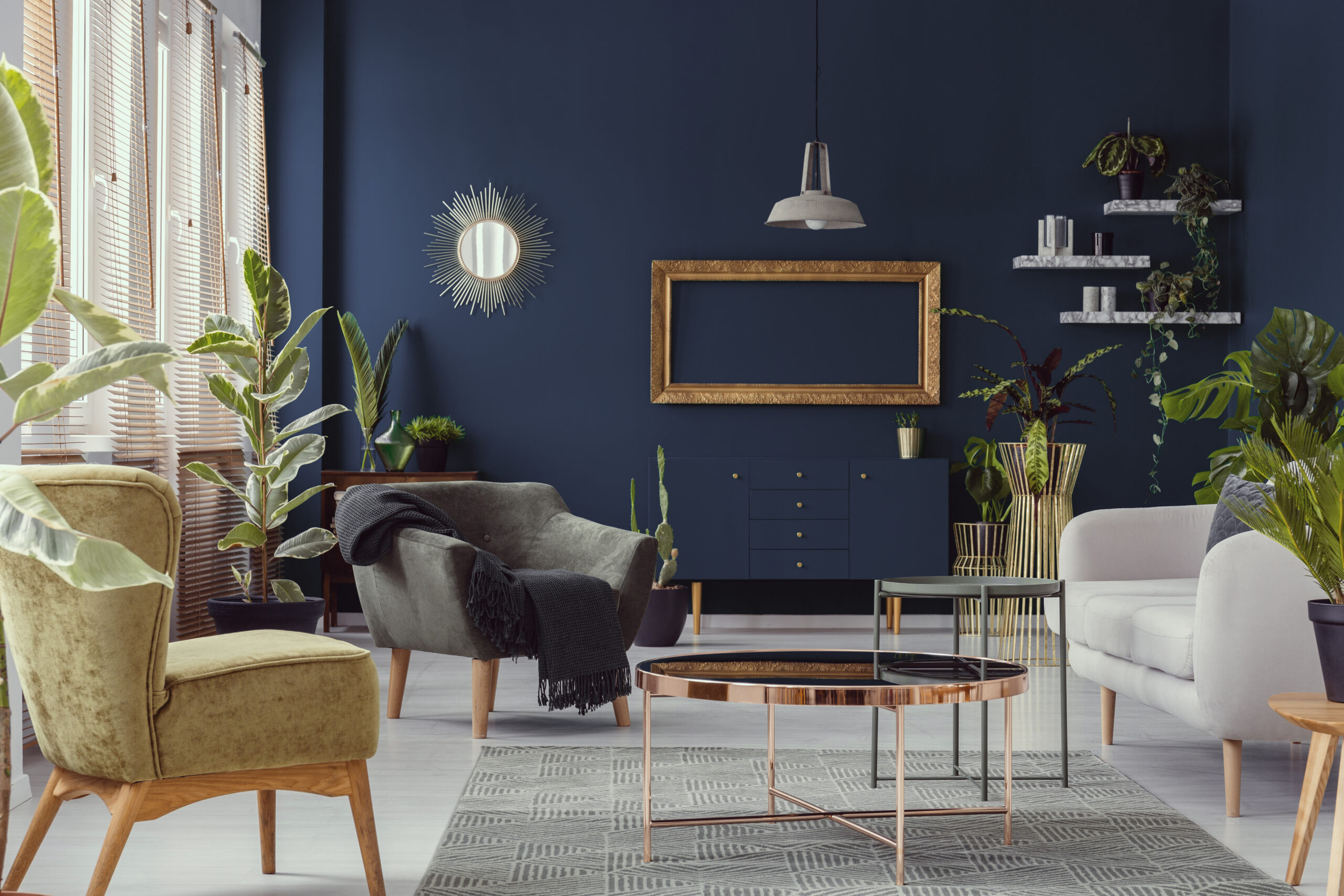 Blue wall in a living room with a golden frame and matching cabinet