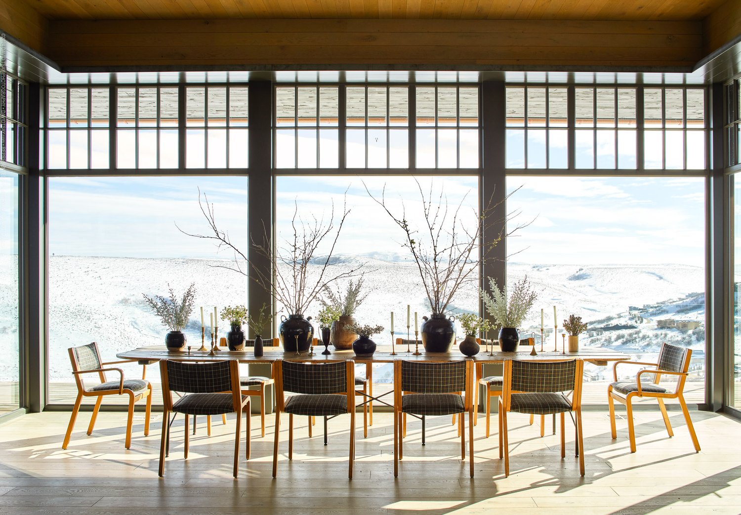 dining area with floor to ceiling windows and a long dining table surrounded by chairs