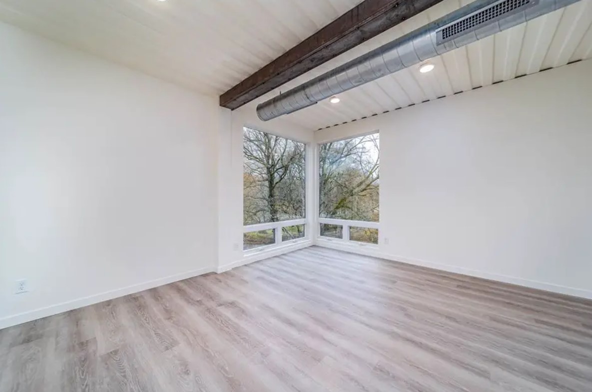 bedroom with floor to ceiling windows in the corner and white walls