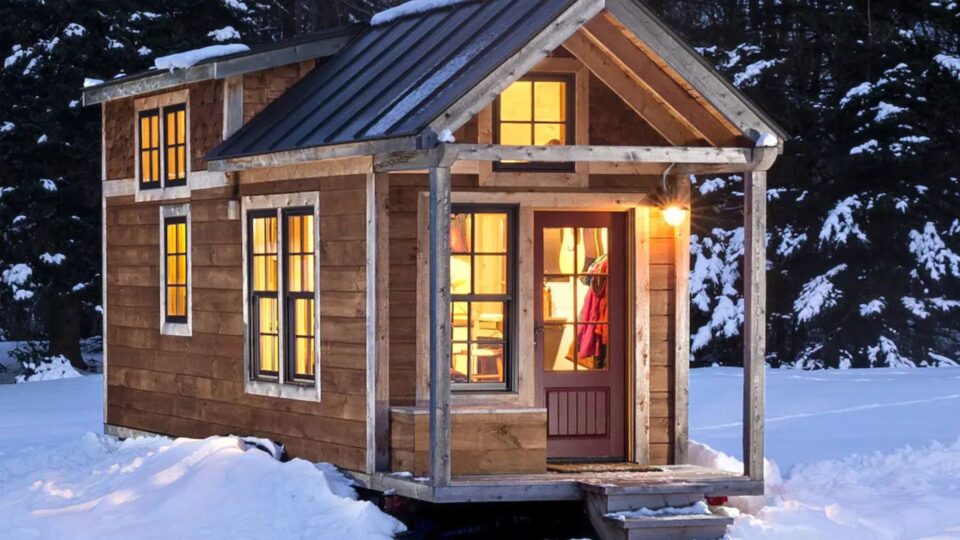 exterior of a tiny home cabin covered in snow