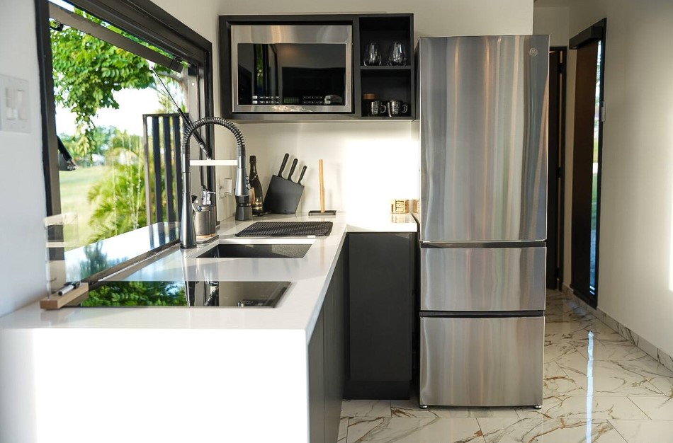 kitchen with a white countertop space, black cabinets and a huge window