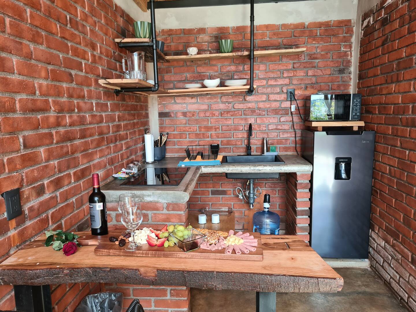 kitchen with a brick wall, wooden bar, open shelves