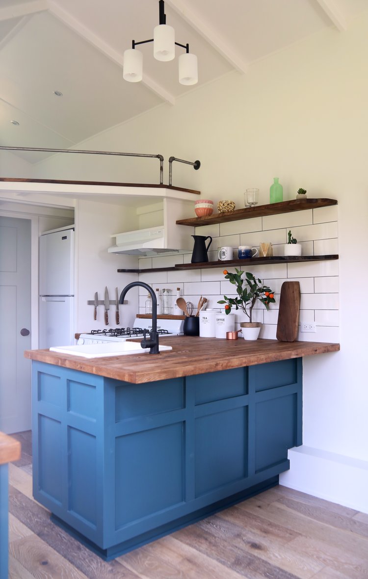 kitchen with dark teal cabinets and wooden countertop and shelves