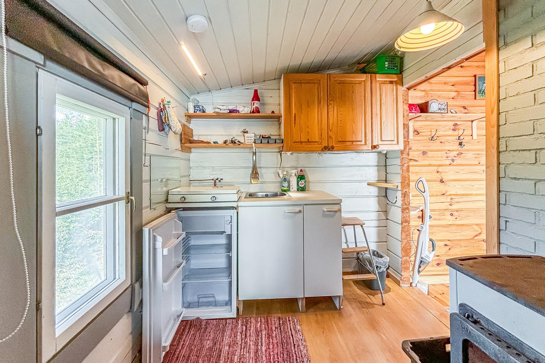 kitchen with white and brown cabinets, tiny white countertop, large window