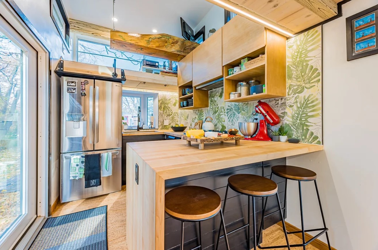 kitchen with glass doors and a lot of windows, brown cabinets and a brown countertop with accompanying bar stools