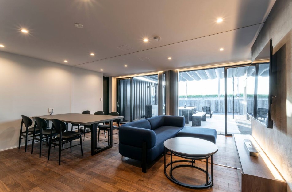 living and dining room with an l-shaped blue couch and a big dining table with black chairs