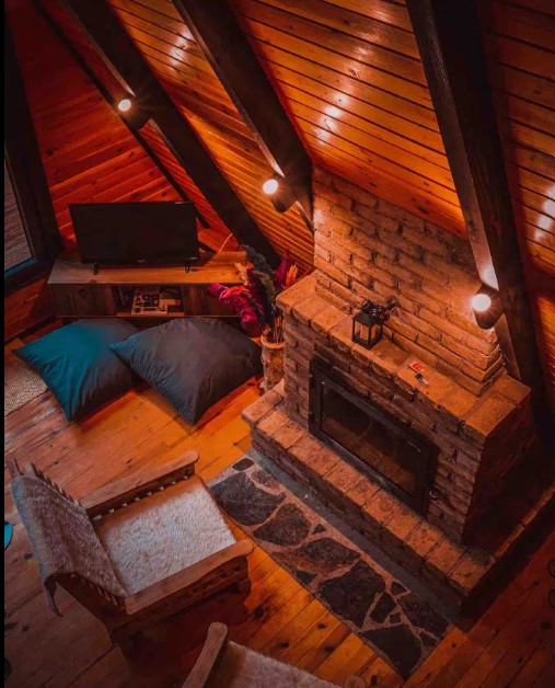 living room with a fireplace, wooden walls, flat screen tv