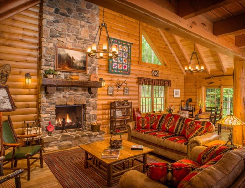 living room with wooden walls, stone fireplace and a brown couch with patterned details