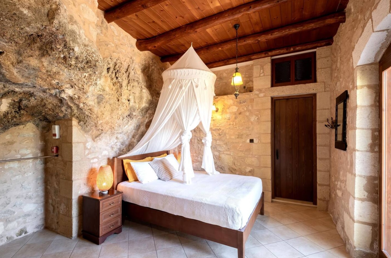 Master bedroom in cave with a full-sized bed and wooden details