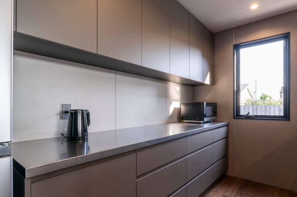 minimalist kitchen with gray cabinets and a big window