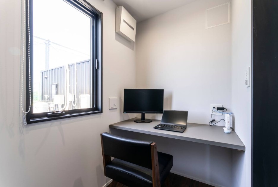 office space with a gray desk, big window, comfy black chair