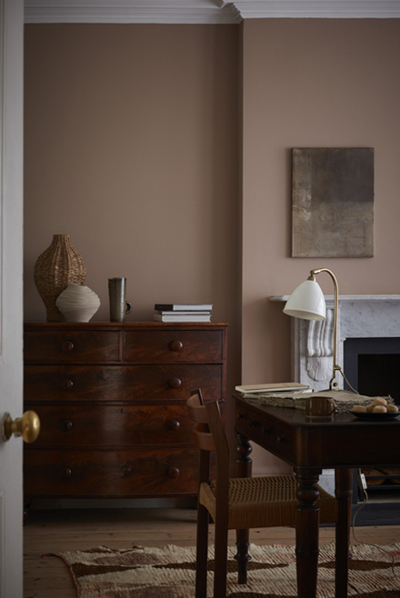 room with mochi beige walls, brown wooden cabinet, brown table accompanied by a chair