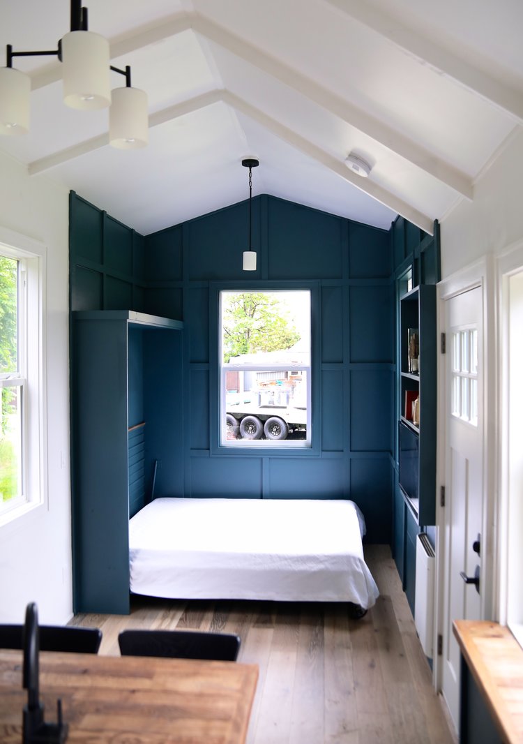 room with dark teal walls and a foldable bed