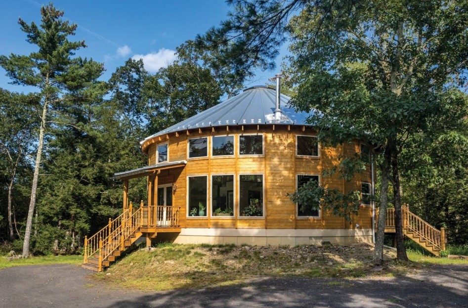 round wooden home surrounded by greenery