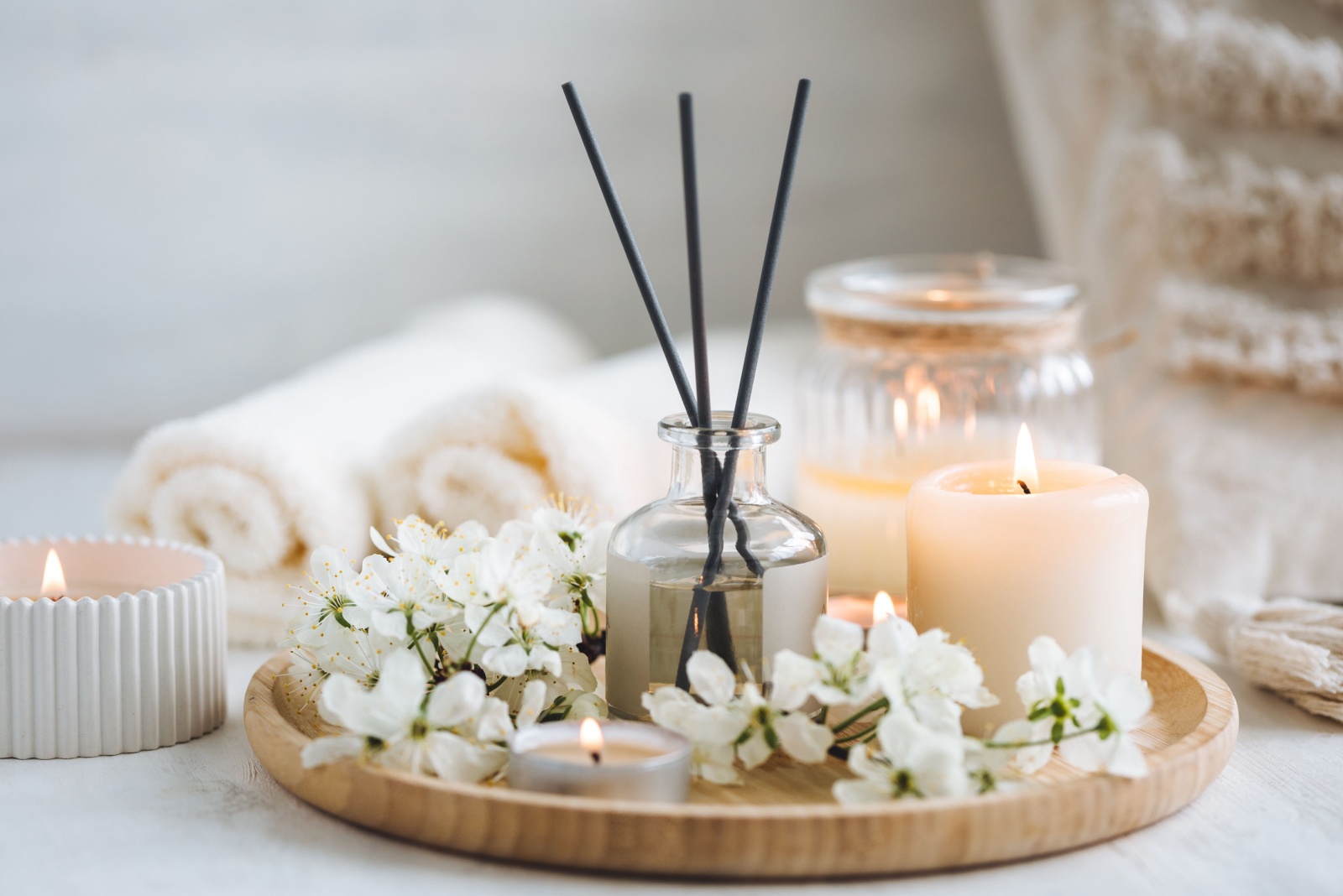 scented candles and flowers on a tray