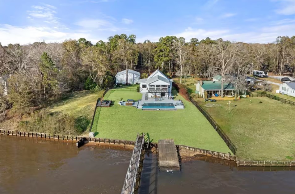 exterior of a home with a pool and big land with a private deck to the lake