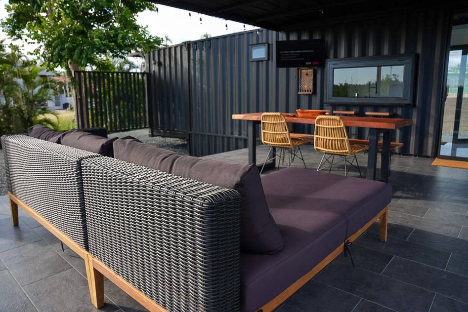 terrace with a dining table surrounded by two chairs and a bench and an l-shaped couch