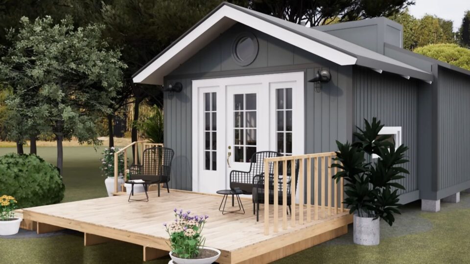 exterior of a tiny home with gray walls and a porch with flowers