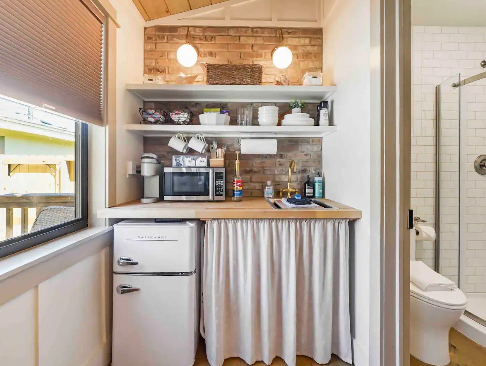 Tiny kitchen with open shelves and a vintage mini fridge