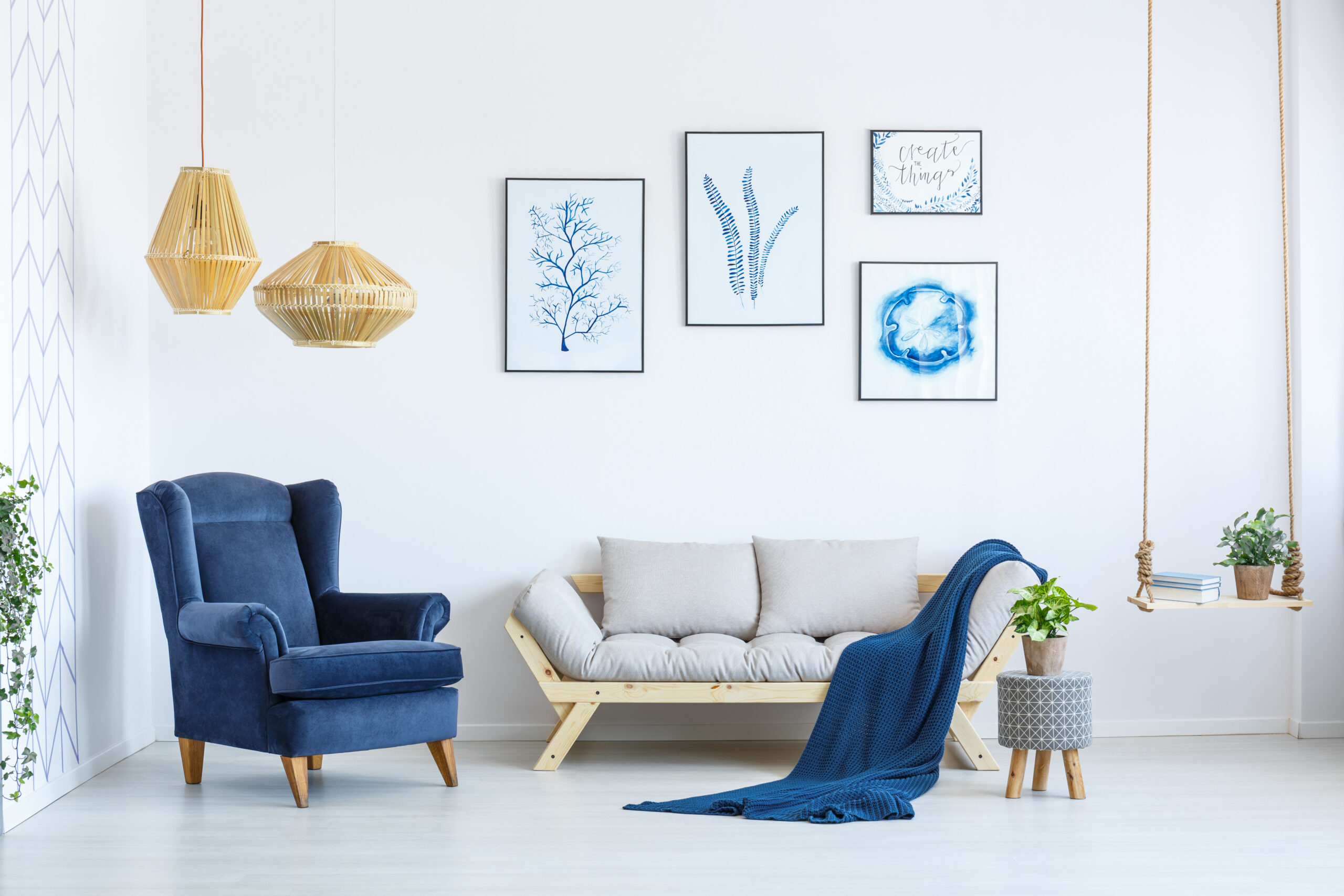 White and blue living room with a blue armchair and wooden decorations